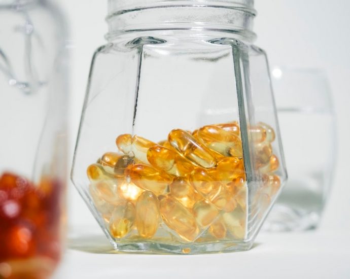 A glass jar filled with jelly beans next to another glass jar filled with jelly beans